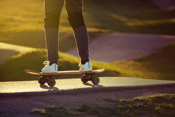 Child in white sneakers running on a skateboard at the skatepark