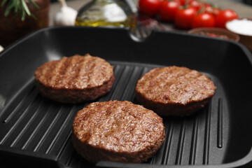 Fototapeta na wymiar Tasty fried hamburger patties on grill pan, closeup