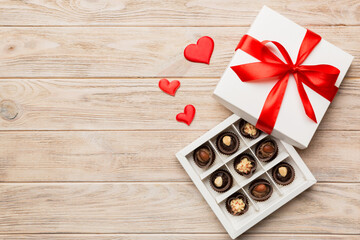 Delicious chocolate pralines in red box for Valentine's Day. Heart shaped box of chocolates top view with copy space