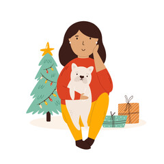 Young girl sitting with her dog. Christmas scene with a pet, holiday tree