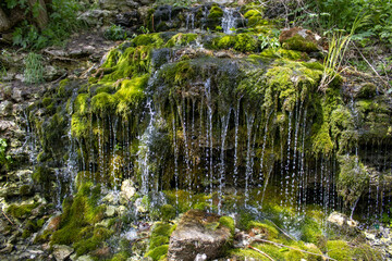 Water flows down on green moss