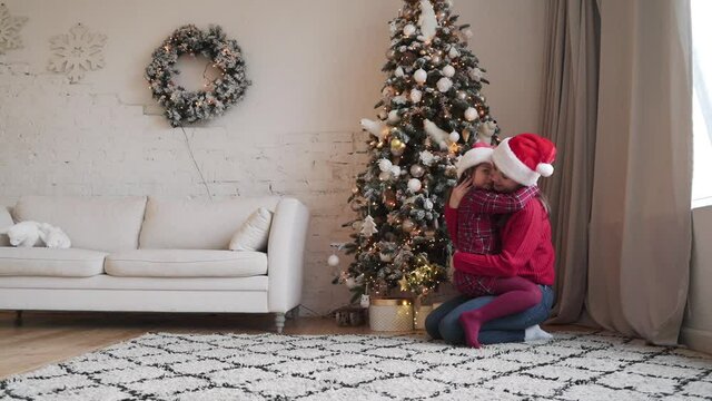  mom little daughter fooling around embrace at home enjoy Christmas holidays