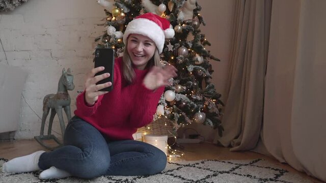 Woman holds smart phone make video call on Christmas congratulates relatives