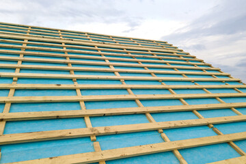 Obraz premium Brick house with wooden roof frame under construction.