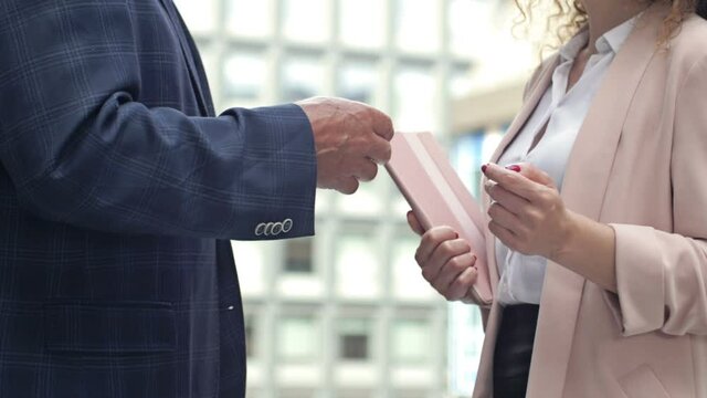 Two business people, a man and a woman, are emotionally talking in the courtyard of the business center.