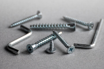 Furniture assembly hardware options and tools on grey background. Furniture fittings. Copy space. Space for text.