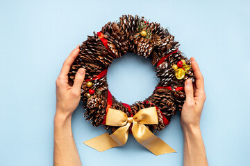 Festive Christmas wreath in hands. New year decoration background