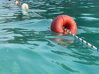 Beach buoys on a rope in the sea. A marker for swimming in blue water. Concept: swimming in the...