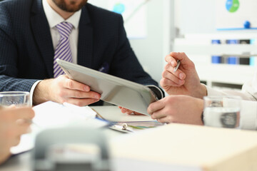 Manager holding special pen and paper tablet with document to sign