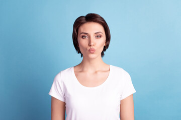 Fototapeta premium Photo of young lovely girl send air kiss romantic feelings flirty date isolated over blue color background