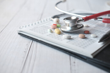  close up of pills and stethoscope on calendar ,