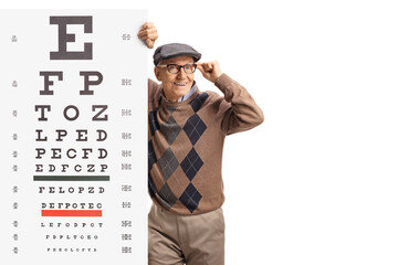 Elderly man wearing glasses and standing next to a vision exam