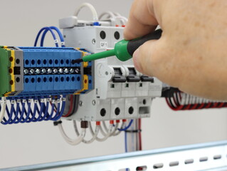 Installation of the mounting wires with a screwdriver in the electrical panel.