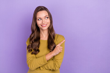 Portrait of gorgeous positive person look indicate finger empty space isolated on purple color background