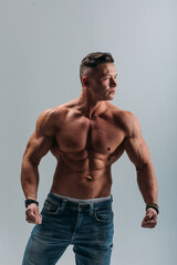 young man, brutal appearance, with a beautiful torso, bodybuilder, in the studio