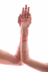 Male and female hands wrapped in red thread isolated on white, concept of desire and love