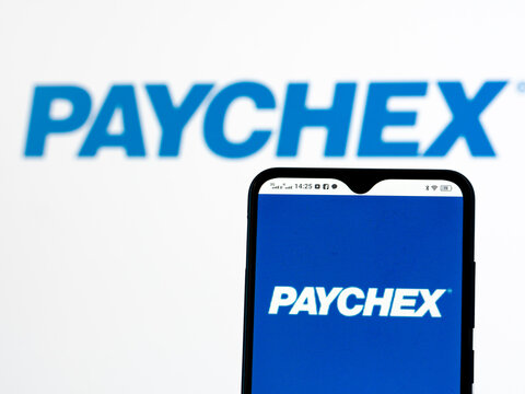 In this photo illustration Paychex, Inc. logo seen displayed on a smartphone in the background.