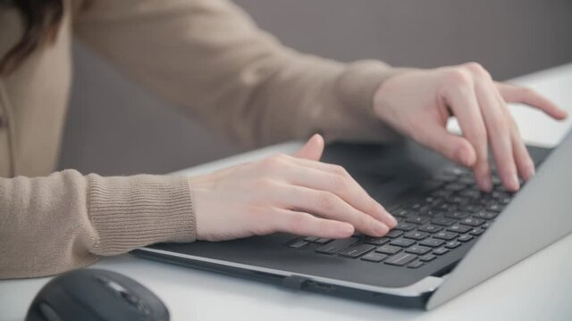 Stock video of freelancer woman typing text on laptop keyboard. Female free lancer working from home through internet while using notebook computer