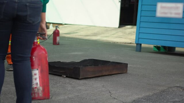 Man teaches or training how to use carbon dioxide (CO2) fire extinguishers to extinguish fires from fuel in house or industry for safety.