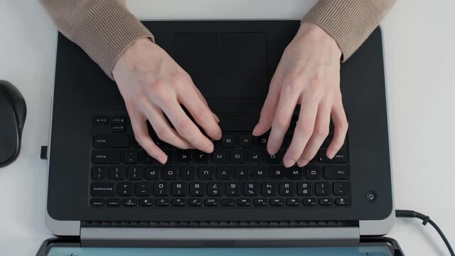 Woman typing text on laptop computer, filmed on office table directly from above in 4K ultra hd. Royalty free stock video of freelancer girl working on notebook at home