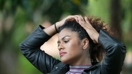 Woman tying hair outside, Brazilian girl ties hair