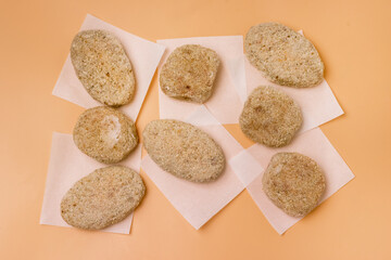 Homemade Frozen Meat Cutlet on Yellow Background Vertical Top View Frozen Semi-finished Products