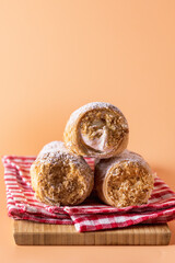 Three Tasty Homemade Pastry Tubes with Cream on Wooden Tray Yellow Background Selective Focus Sweet Tube with Whipped Cream Close Up