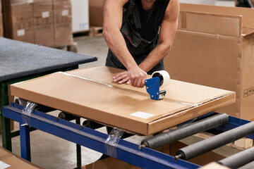 The worker prepares the packaging of furniture for further sale. Industrial production of furniture.