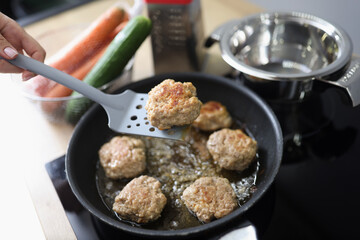 Tasty aromatic meat balls frying in oil on pan on kitchen stove