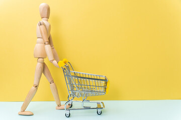 Mini cart supermarket with wooden mannequin Concept of delivery, online shopping. Copy space.