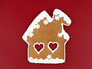 Romantic gingerbread house with heart shaped windows, red background. Sweet home, love and togetherness, winter time 
