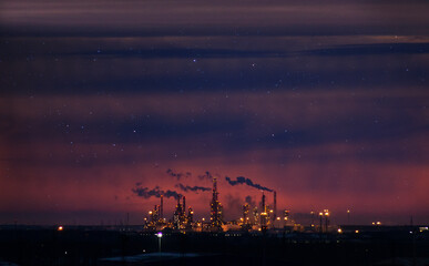 The smoke from the pipes of the metallurgical plant pollutes the environment. Night photo. Space for copying text