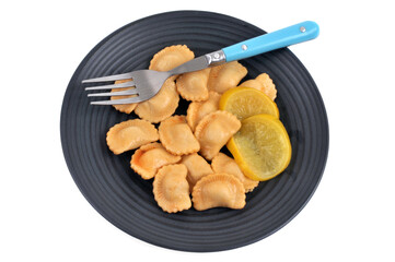 Assiette de raviolis au citron avec une fourchette sur fond blanc