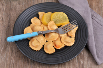 Assiette de raviolis au citron avec une fourchette servie à table vue de dessus