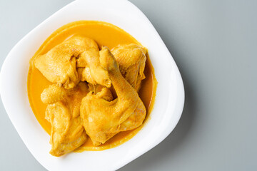 Indonesian Traditional cuisine : Ayam Gulai Padang. Ayam Gulai is a popular dish of chicken curry from Padang, West Sumatra. served on plate and isolated on gray background.