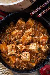 Closeup of chinese spicy mapo tofu made of tofu cubes and ground pork, vertical shot, above view