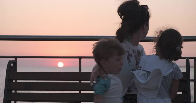 Mom Kisses Her Kids On The Pier