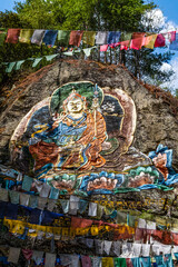 Colorful image of Guru Rinpoche op a rock near Tango Goemba monastery in Bhutan, Asia