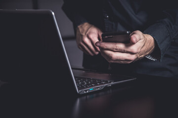 Businessman using a smartphone and notebook in a moddy office