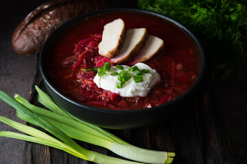 Traditional Ukrainian cuisine - borscht with sour cream and green onions