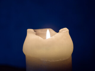 Burning candle in the dark close-up.