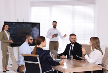 Business training. People in meeting room with interactive board