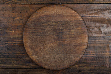 Cutting kitchen board on brown wooden table. Space for text.