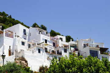 Fototapeta na wymiar Beautiful Frigiliana village, Spain Whitewashed traditional houses on a steep hillside Dramatic landscape with view of the old town Blue sky and copy space