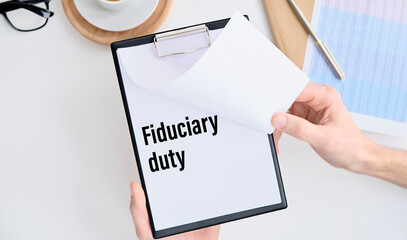 Paper with Fiduciary duty on a clipboard in hands businessman.
