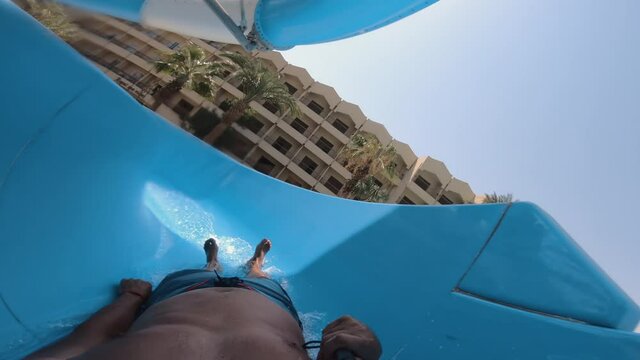 Man having fun and sliding down in a water slide