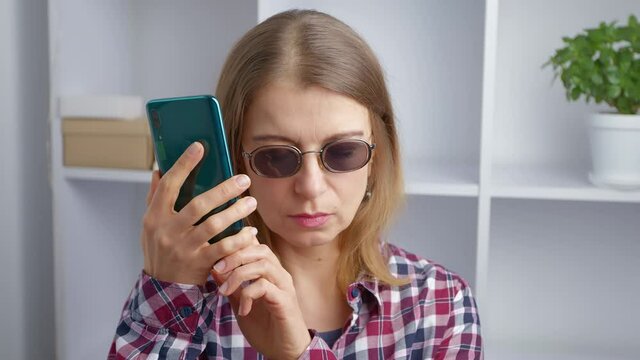 Blind woman woman uses the phone.