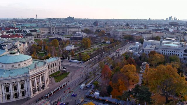 Beautiful Vienna skyline with autumn city street scene ft aerial view of Austria&rsquo;s capital. Above of Rathaus Park hosting a Christmas Market around trees by Parliament, Hofburg Palace and Burgtheater 