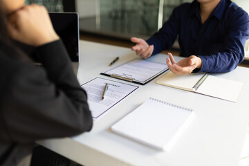 The life insurance agent makes an explanatory gesture while talking to the customer.
