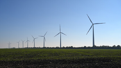Wind turbines on blue sky background - 475539431